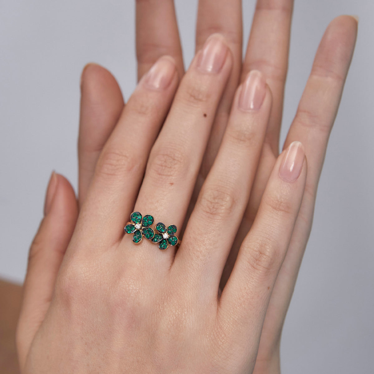 Anillo oro amarillo 18K flores unidas con esmeraldas y brillante central