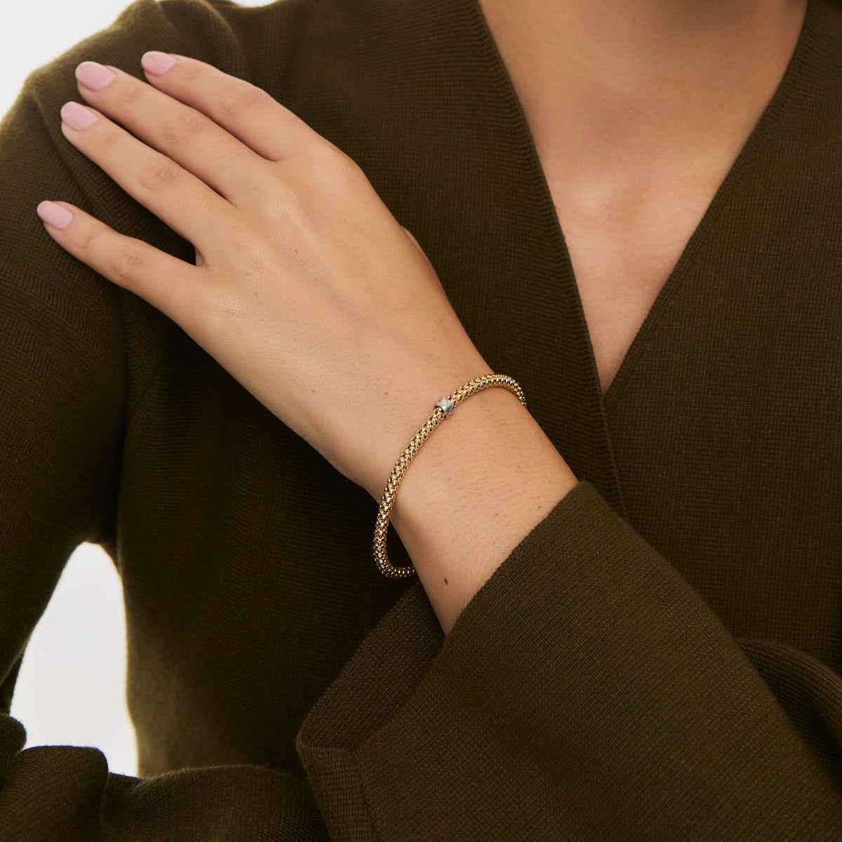 Pulsera en dos oros 18K elástica con terminaciones en forma de bolas