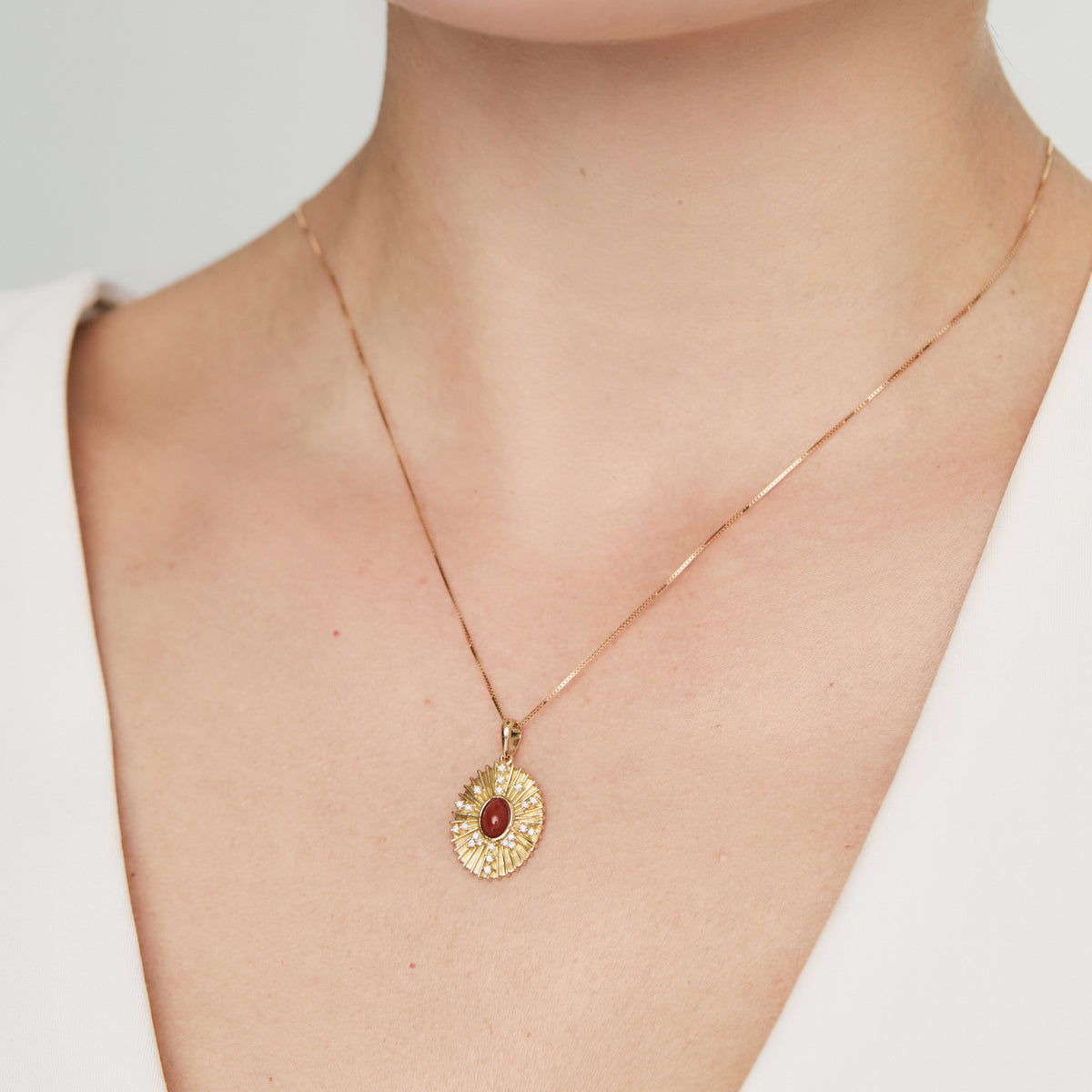 Dije en oro amarillo 18K oval bajo relieve con coranlina y brillantes