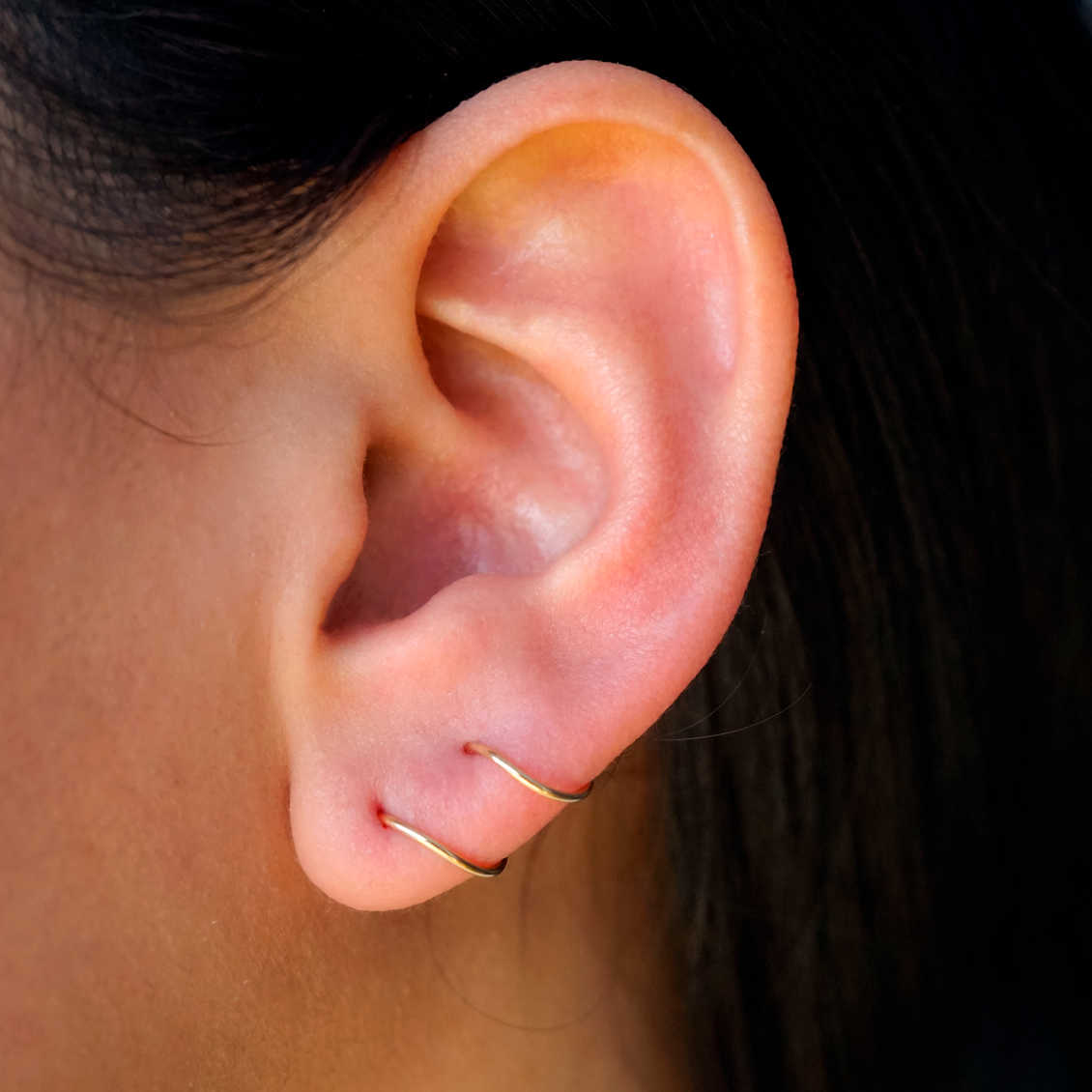 Medio arete en oro amarillo de 18K piercing envolvente