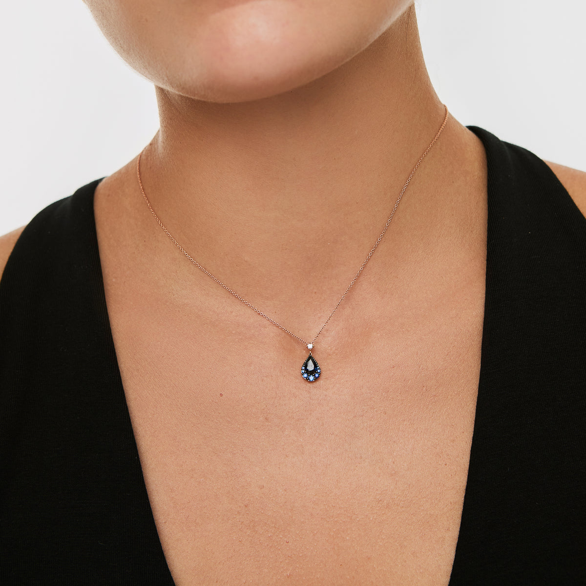 Collar en oro amarillo de 18K con dije pera en zafiros y brillantes con rodio negro