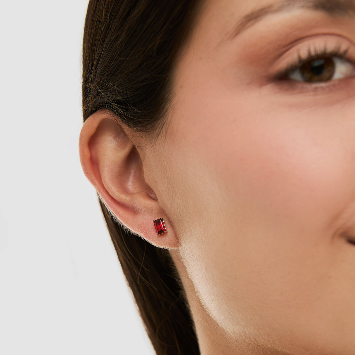 Aretes oro amarillo 18K punto de luz con granate corte esmeralda