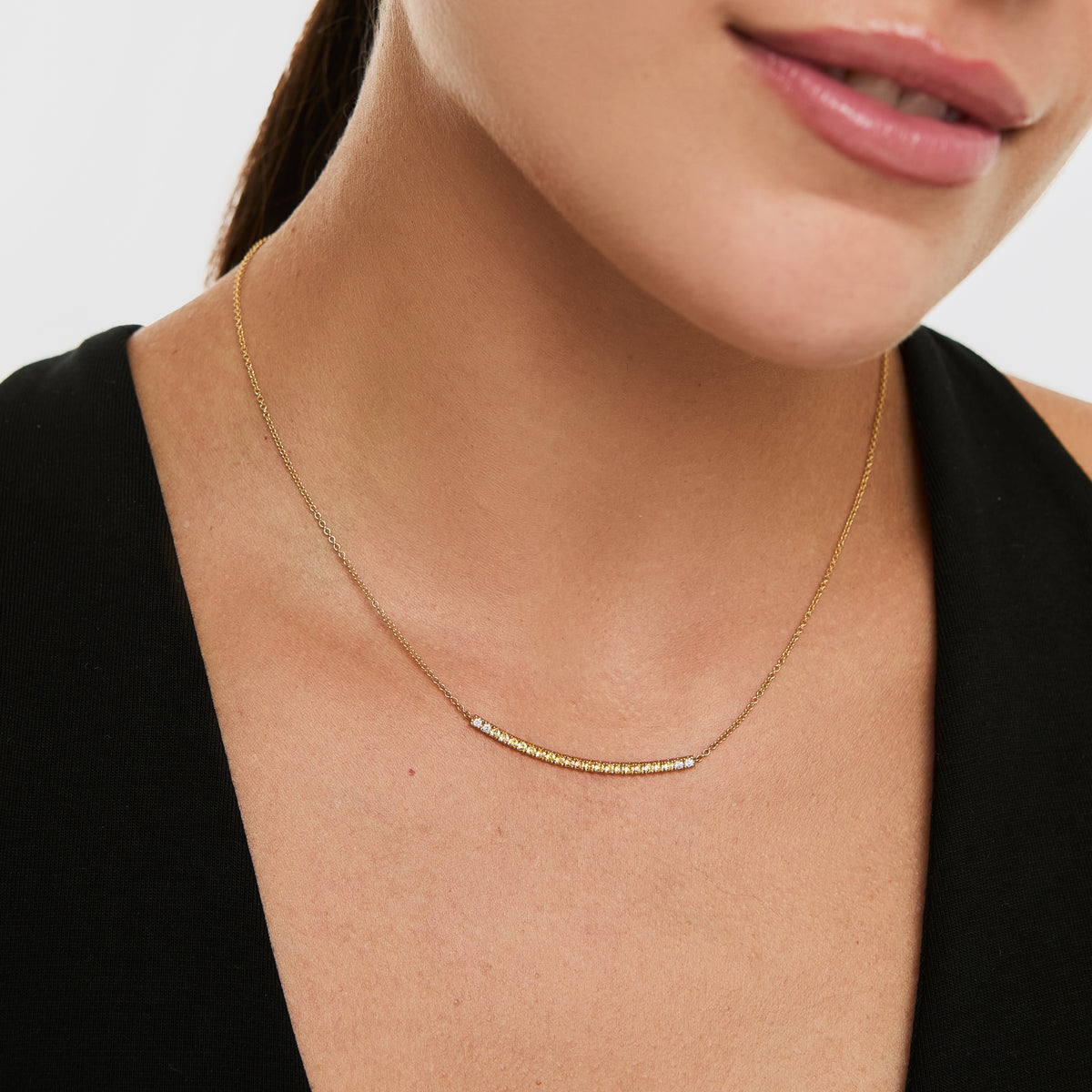 Collar en oro amarillo de 18K barrita curvo con zafiro amarillo