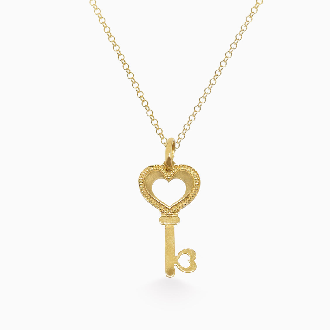 Dije en oro amarillo de 18K en forma de llave con corazón